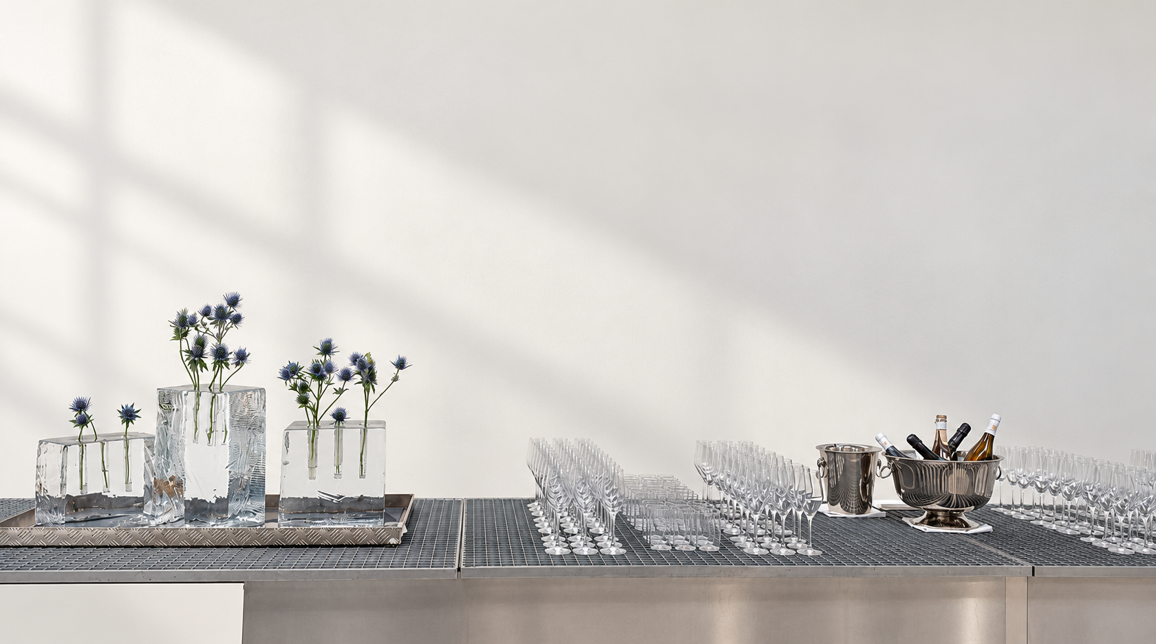 Décor floral minimaliste dans des contenants métalliques sur un bar gris